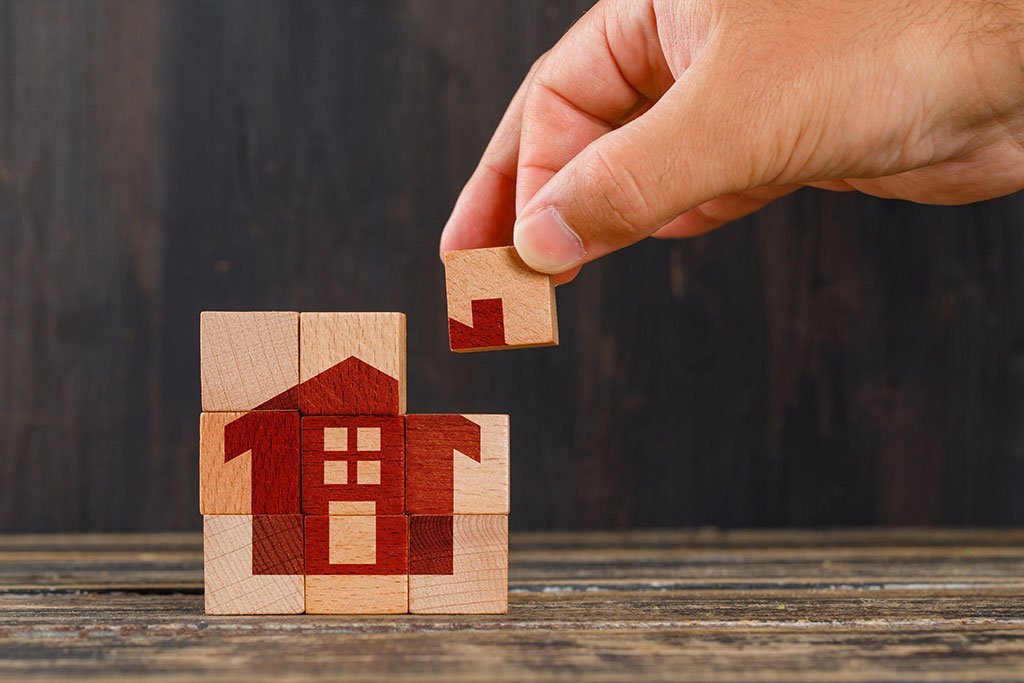 Segundo crédito, concepto en vista lateral colocando un cubo de madera que completa la imagen de una casa